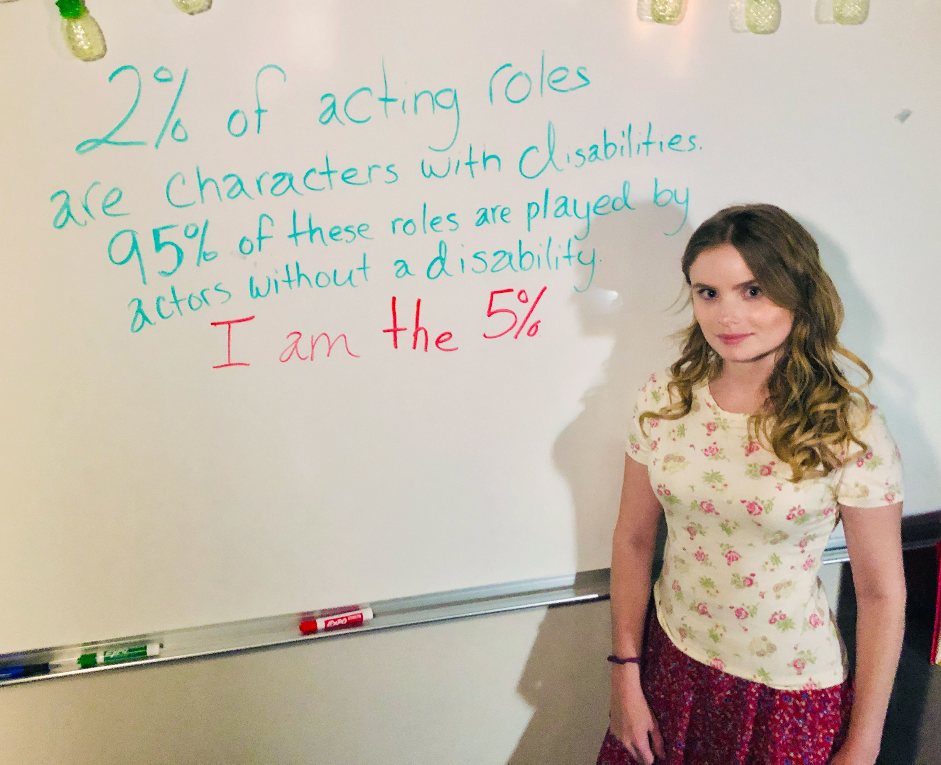 Kayla posing by a whiteboard.
