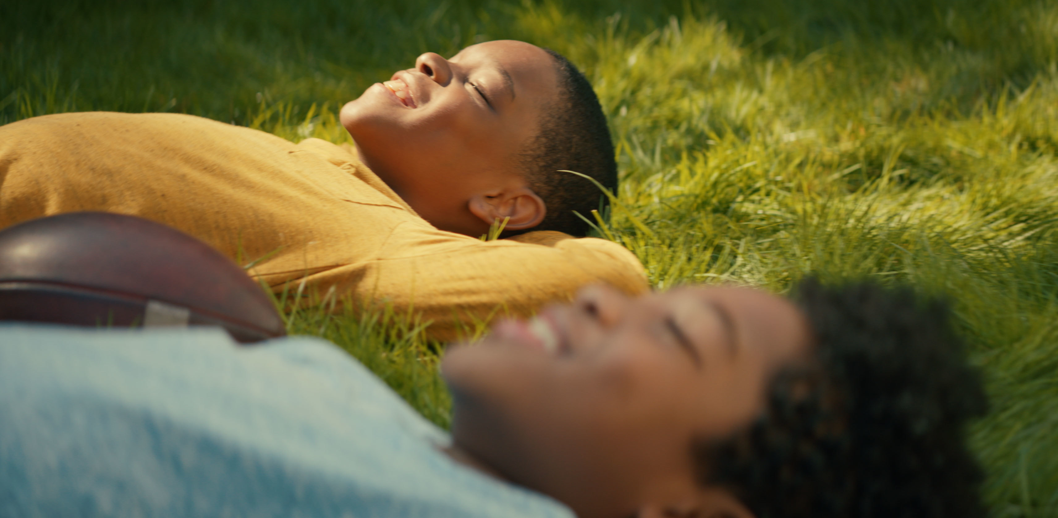 An image of two boys looking up at the sky and smiling.