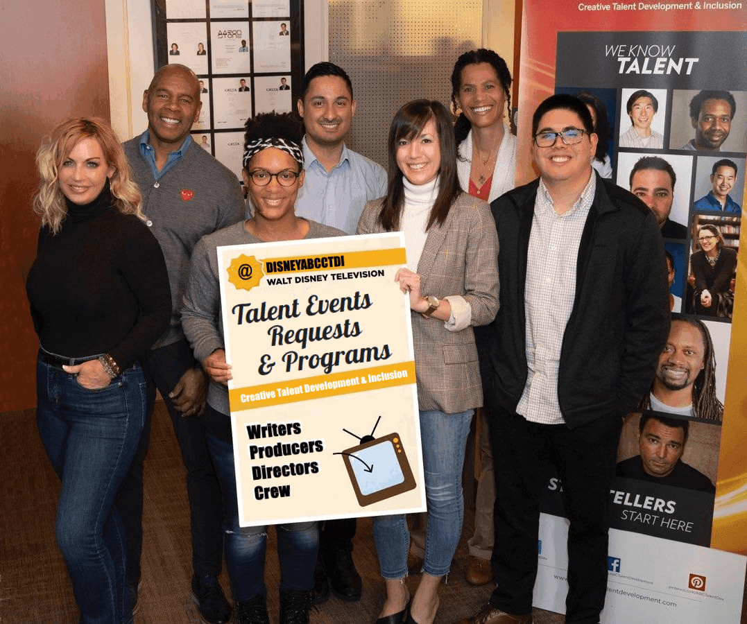 A photo of seven people posing with a poster